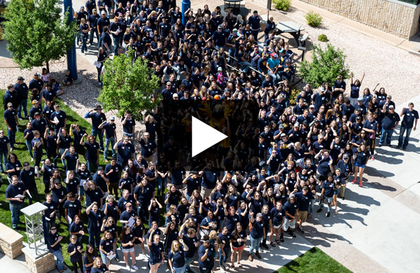 overhead view of crowd of students on  campus with video play button